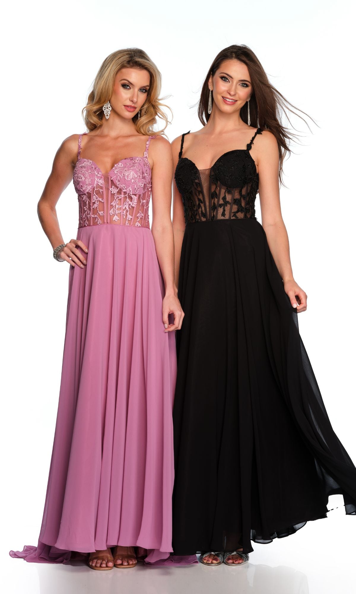 Two women smile at the camera—one in a pink, the other in a black version of the Long Formal Dress 11582 by Dave and Johnny, both featuring lace embroidery, sheer panels, and an elegant sleeveless A-line design.